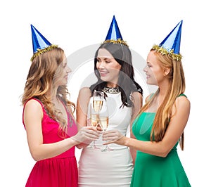 Three women wearing hats with champagne glasses