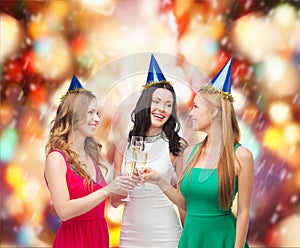 Three women wearing hats with champagne glasses