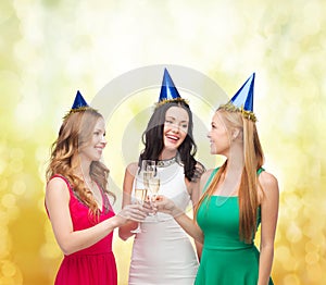 Three women wearing hats with champagne glasses