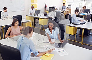 Three women working together in a busy office, elevated view