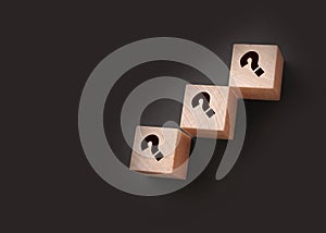 Three wooden blocks with black question marks. Faq questions and answers concept. Educaion or business project concept