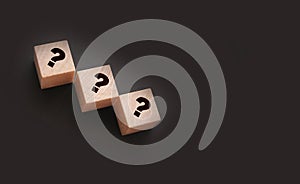 Three wooden blocks with black question marks. Faq questions and answers concept. Educaion or business project concept