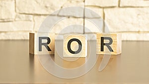 three wooden blocks with text ROR on a gray stone background