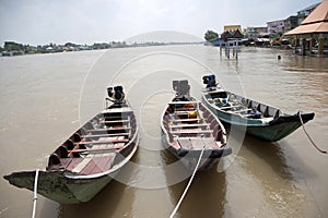 Three wooden boat machine landing on the water in the river.