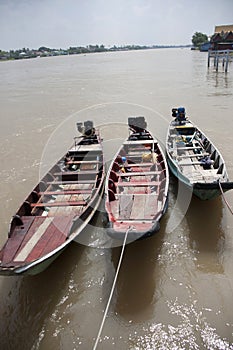 Three wooden boat machine landing on the water in the river.