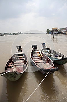 Three wooden boat machine landing on the water in the river.