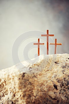 Three wooden cross on Calvary hill, grey background. Crucifixion, resurrection of Jesus Christ. Christian Easter holiday