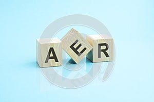 three wooden cubes with the letters AER on the bright surface of a blue table photo