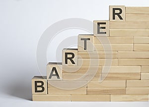 Three wooden cubes with letters BARTER on the white table