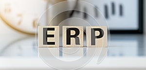 Three wooden cubes with letters ERP - stands for Enterprise Resource Planning on a light table