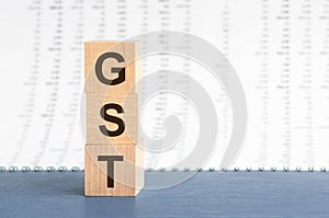 Three wooden cubes with letters GST - short for Goods and Services Tax, concept