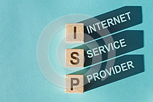 Three wooden cubes with letters ISP - Internet Service Provider, on blue table photo