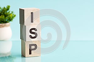 Three wooden cubes with letters ISP - Internet Service Provider, on blue table, more in background, space for text in right