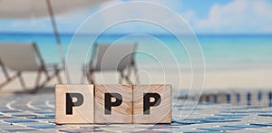 Three wooden cubes with letters PPP on ocean beach. Business concept