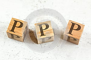 Three wooden cubes with letters PPP stands for Praise Picture Push on white board.