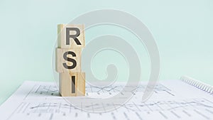 Three wooden cubes with letters RSI - means Relative Strength Index, on white table.