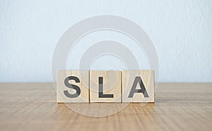 Three wooden cubes with letters SLA means Service Level Agreement