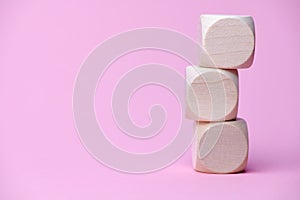 three wooden cubes on pink paper with copy space