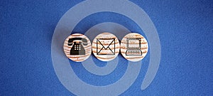 Three wooden cut circles with contact and information icons on them