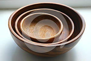 Three wooden empty food bowls stacked on top of each other