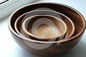 Three wooden empty food bowls stacked on top of each other