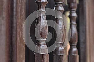 Three wooden fence pillars patterned in dark brown