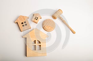 Three wooden houses and a hammer of the judge on a white background. Court cases on property and real estate. Confiscation and nat