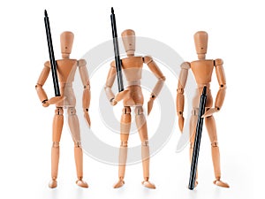 Three wooden mannequins holding pens as armed guards