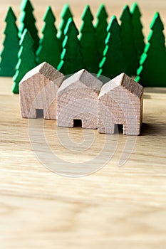 Three wooden row houses surrounded by tall trees in the background. Sustainable housing, real estate and insurance concepts. With