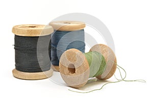 Three wooden spools of thread