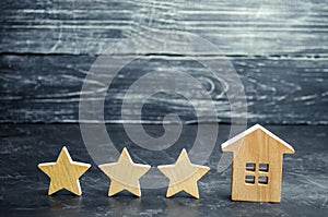 Three wooden stars and a house. Three star hotel or restaurant. Review of the critic. Quality of service and level of service.