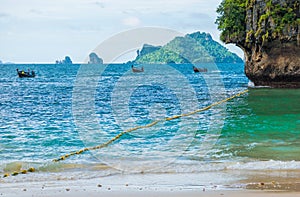 Three wooden Thai boats a long tail in the sea mooring