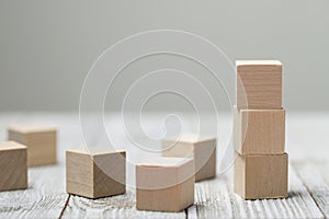 Three wooden toy cubes on grey wooden background