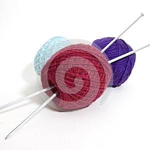 Three wool balls and knitting needles