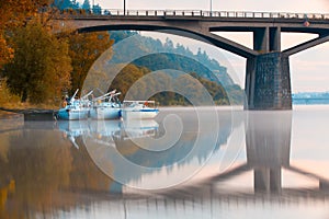 Three yachts in the harbor under a bridge in Prague