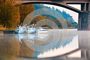 Three yachts in the harbor under a bridge in Prague