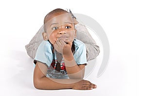 Three year old black boy lying down smiling