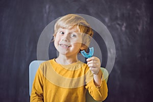 Three-year old boy shows myofunctional trainer. Helps equalize t