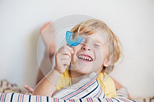 Three-year old boy shows myofunctional trainer to illuminate mouth breathing habit. Helps equalize the growing teeth and correct