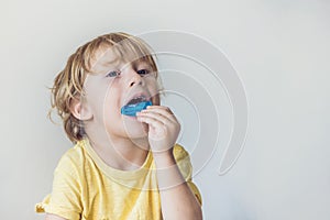 Three-year old boy shows myofunctional trainer to illuminate mouth breathing habit. Helps equalize the growing teeth and correct