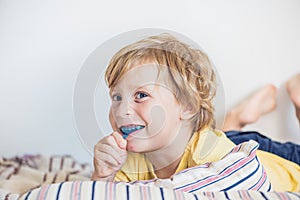Three-year old boy shows myofunctional trainer to illuminate mouth breathing habit. Helps equalize the growing teeth and correct b photo