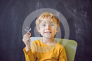 Three-year old boy shows vestibular plate. Plate with a bead to photo