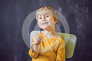 Three-year old boy shows vestibular plate. Plate with a bead to photo