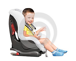 Three-year-old boy sits in an automobile children`s chair