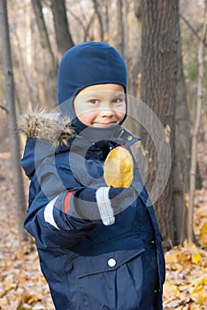 Three year old boy with yellow leaf