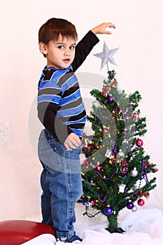 Three year old Christmas boy and little Christmas tree