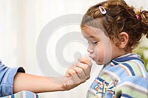 A three-year-old girl spits into a saliva test tube for covid19 antigens photo