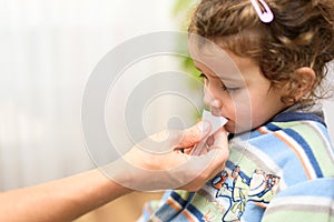 A three-year-old girl spits into a saliva test tube for covid19 antigens photo