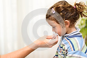 A three-year-old girl spits into a saliva test tube for covid19 antigens photo