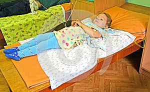 The three-year-old sick girl on treatment in a physiotherapeutic office